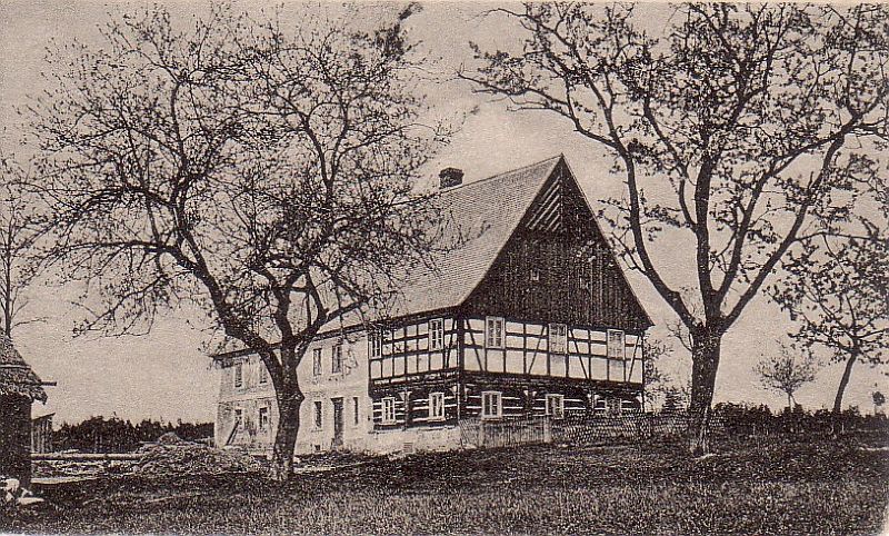  Historick&yacute; sn&iacute;mek podst&aacute;vkov&eacute;ho domu z roku 1919, na kter&eacute;m je patrn&eacute; hr&aacute;zděn&eacute; patro, v&yacute;zdoba &scaron;t&iacute;tu i zv&yacute;&scaron;en&iacute; podezd&iacute;vky rouben&eacute; světnice.