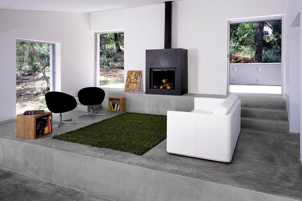 Dům ve svahu - interi&eacute;r ob&yacute;vac&iacute;ho pokoje s krbem a pohovkou.