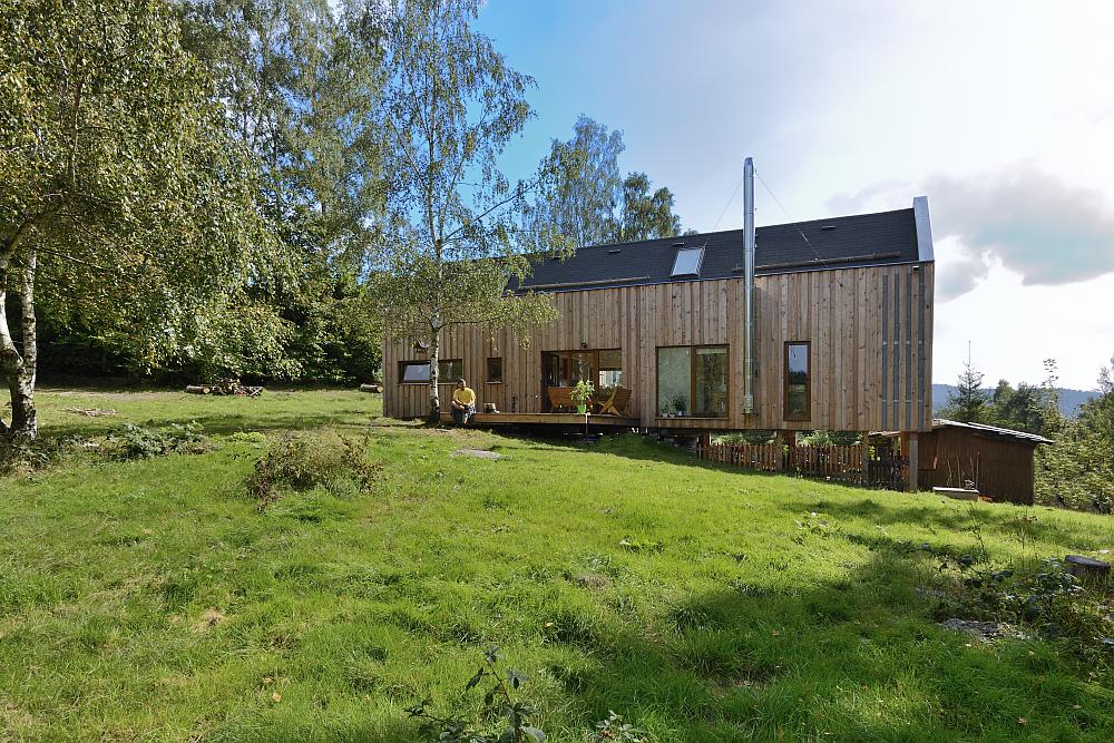 Dům ve svahu obložen&yacute; dřevem.