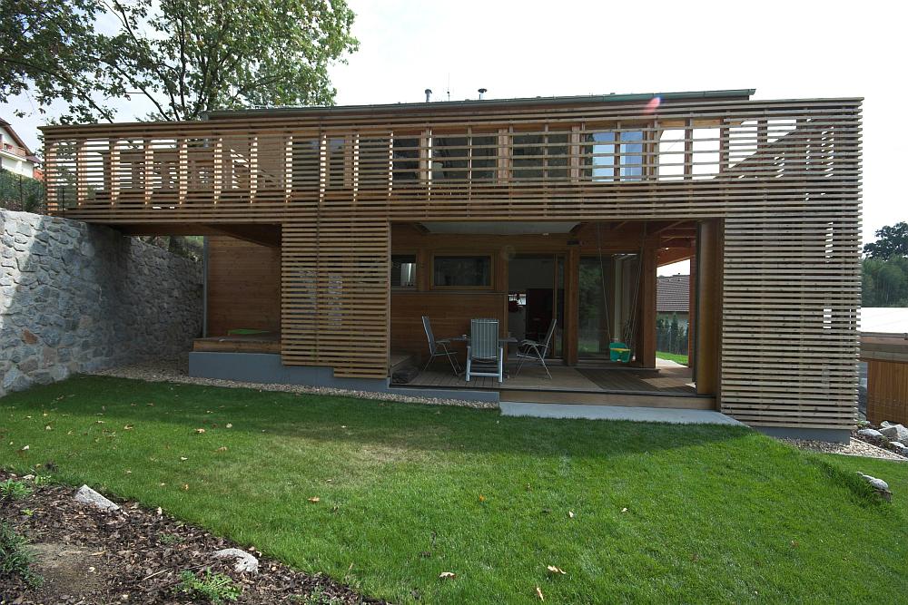 Rodinn&yacute; dům ve svahu v Zaječic&iacute;ch v podobě dřevostavby s terasou.