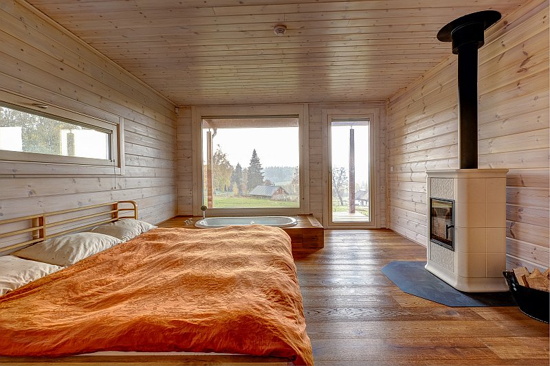 drevostavba-pro-venkovske-bydleni-kontio-severska-borovice-finske-drevostavby-interier-hlavni-obytny-prostor-krb-loznice-s-vanou-krbova-kamna