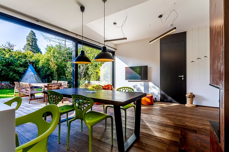 navsteva-drevostavby-bydleni-expresivne-studio-labor-13-interier-hlavni-obytny-prostor-jidelni-stul-velkoformatova-okna-vstup-na-terasu-vyhled-do-zahrady