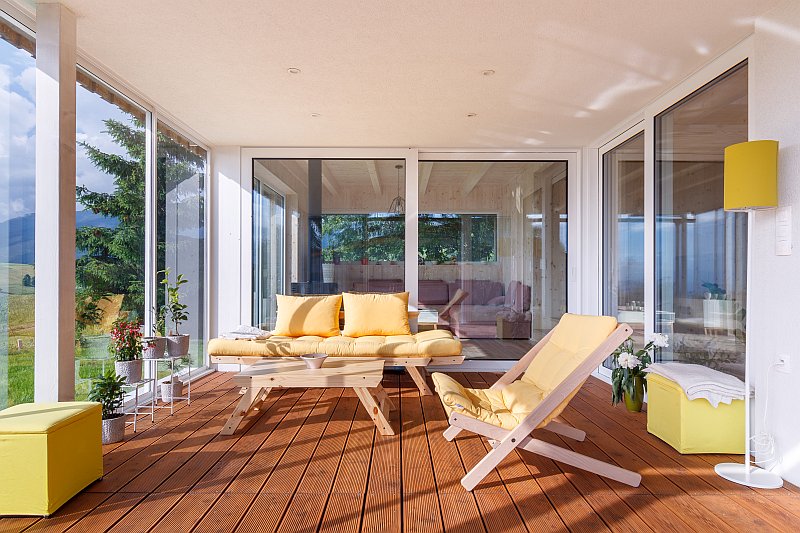 navsteva-drevostavby-dotazeny-v-kazdem-detailu-prodesi-domesi-interier-posezeni-na-kryte-terase-velkoformatova-okna