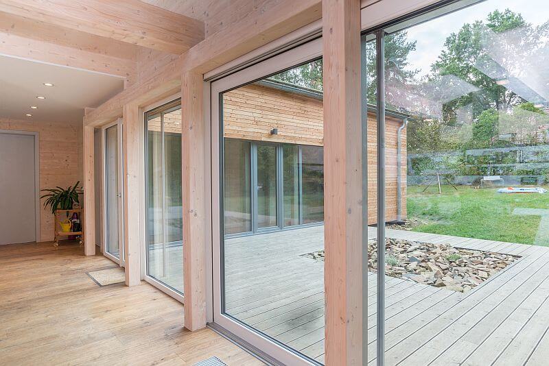 navsteva-drevostavby-novodoba-tvrz-prodesi-domesi-interier-obyvaci-pokoj-proskleni-velkoformatova-okna-vstup-na-terasu