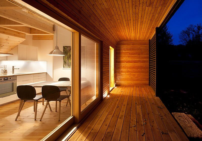 navsteva-drevostavby-unik-z-velkomesta-majo-architekti-drevena-terasa-velkoformatova-posuvna-okna-stineni-slunolam-vecer