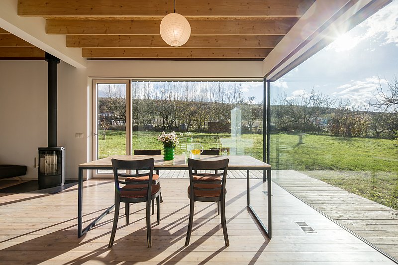 navsteva-drevostavby-vsechno-ma-svuj-cas-molo-architekti-interier-jidelni-kout-krbova-kamna-velkoformatova-okna-vyhled-do-zahrady