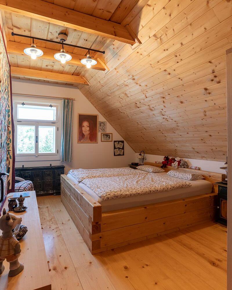 navsteva-drevostavby-vysnene-bydleni-v-tradicnim-stylu-roubenky-strihavka-interier-loznice-v-podkrovi-drevena-postel