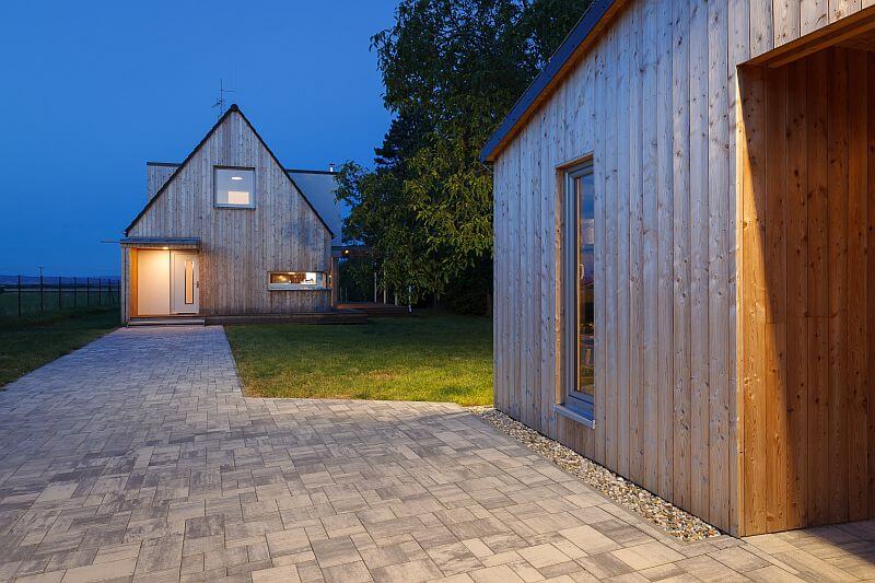 moderni-drevostavba-prodesi-domesi-exterier-drevena-fasada-terasa-sedlova-strecha-vchod-chodnik-garaz-vecer-foto-milan-hutera