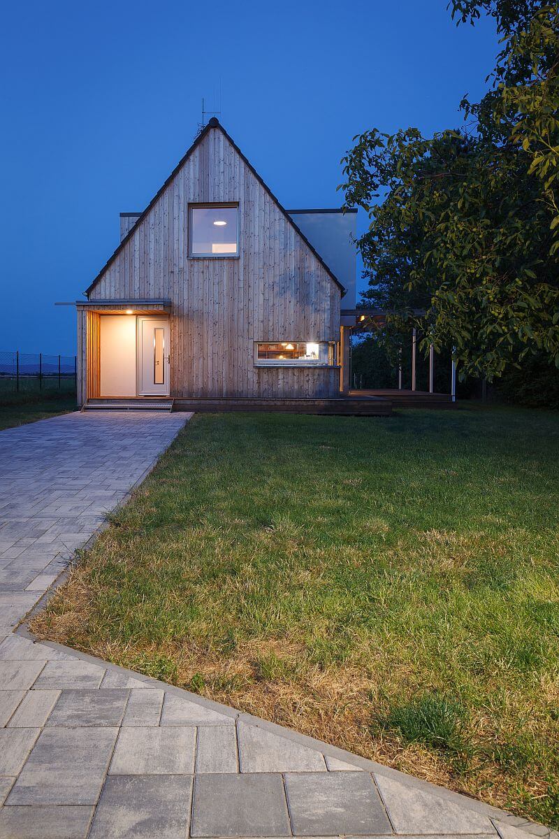 moderni-drevostavba-prodesi-domesi-exterier-drevena-fasada-terasa-sedlova-strecha-vchod-chodnik-vecer-foto-milan-hutera