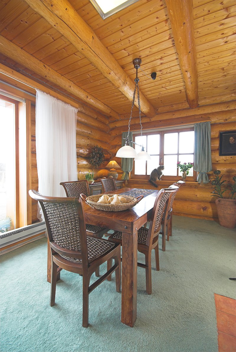 srub-z-kulatiny-masivni-drevostavba-interier-jidelni-stul-podlaha-plosny-koberec