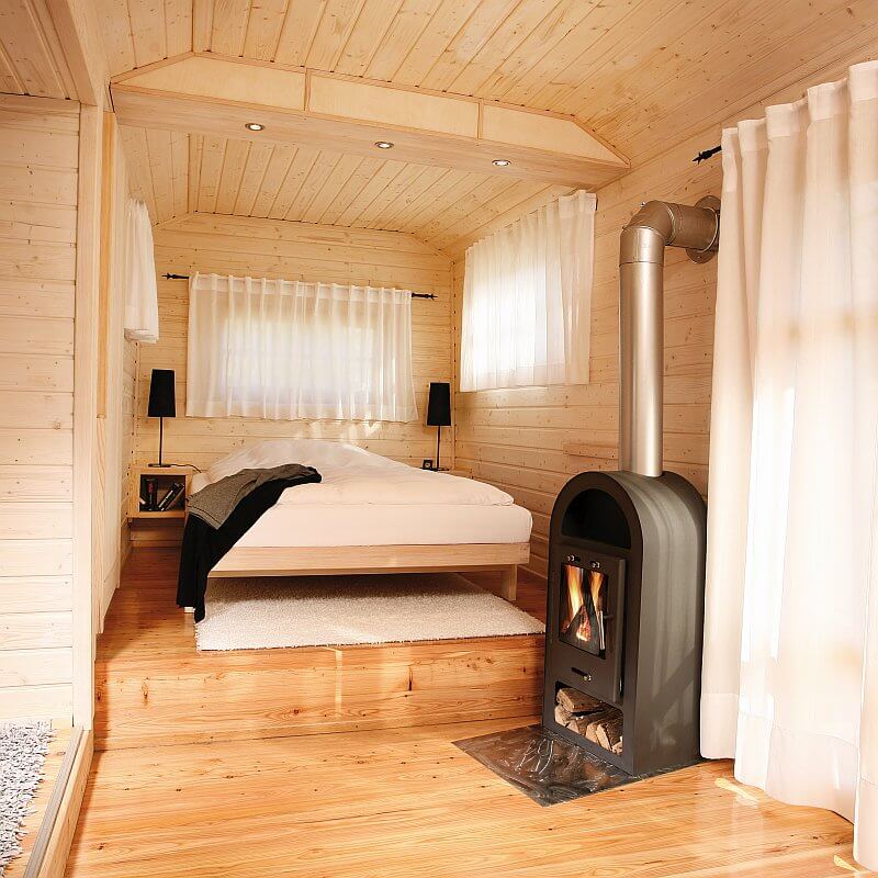 wohlwagen-mobilni-dum-na-kolech-drevostavba-moderni-maringotka-interier-loznice-rozlozena-postel-krbova-kamna-drevena-podlaha-tinified