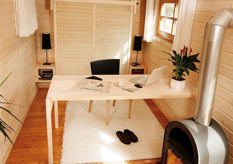 wohlwagen-mobilni-dum-na-kolech-drevostavba-moderni-maringotka-interier-pracovna-dreveny-stul-krbova-kamna-tinified